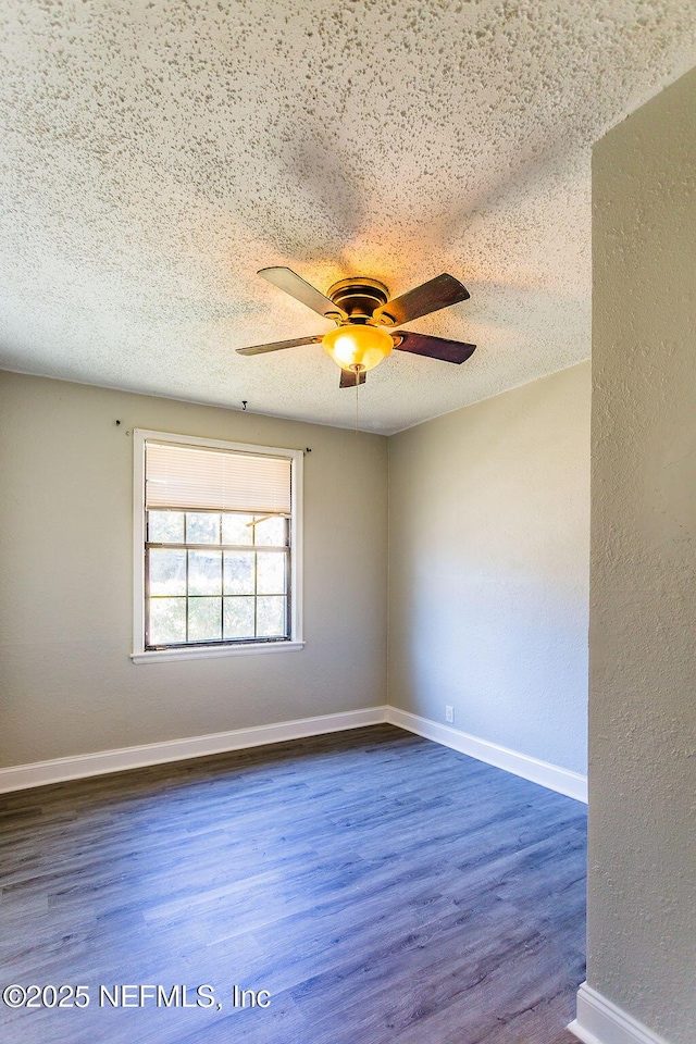 spare room with dark wood-type flooring, ceiling fan, and a textured ceiling