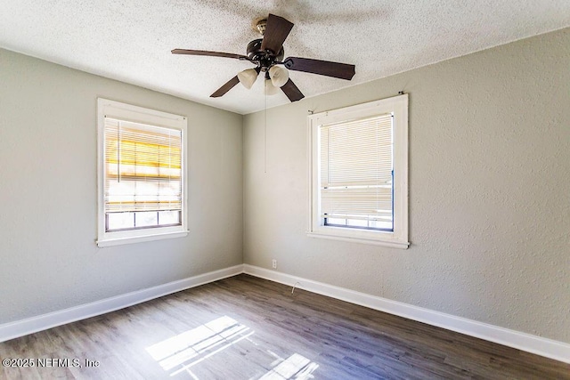 empty room featuring ceiling fan, dark wood-type flooring, and a textured ceiling