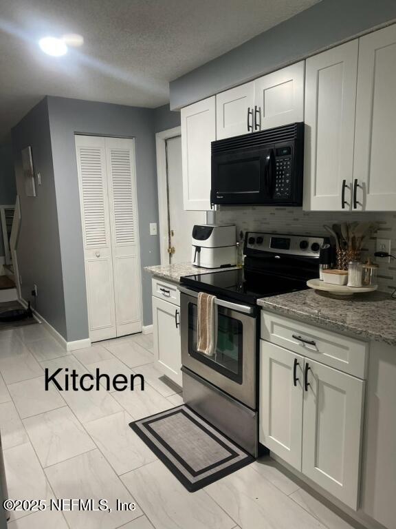 kitchen featuring white cabinetry and stainless steel range with electric cooktop