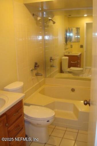 full bathroom featuring toilet, vanity, tiled shower / bath, and tile patterned flooring