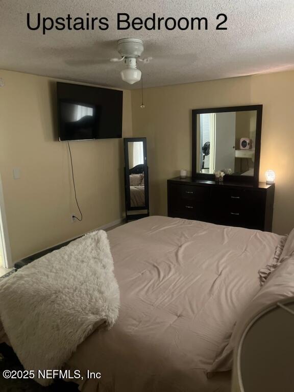 bedroom featuring a textured ceiling and ceiling fan