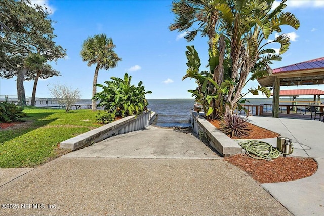 surrounding community with a gazebo, a water view, and a yard