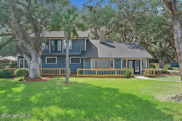 view of front of home with a balcony and a front lawn