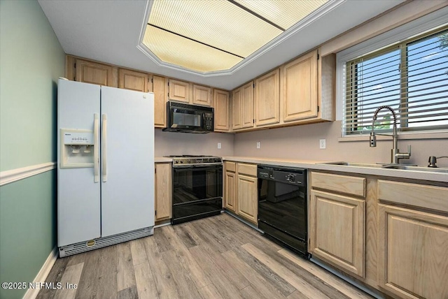 kitchen with light hardwood / wood-style flooring, sink, light brown cabinets, and black appliances