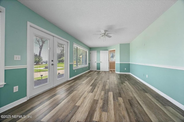 unfurnished room with dark hardwood / wood-style flooring, ceiling fan, french doors, and a textured ceiling