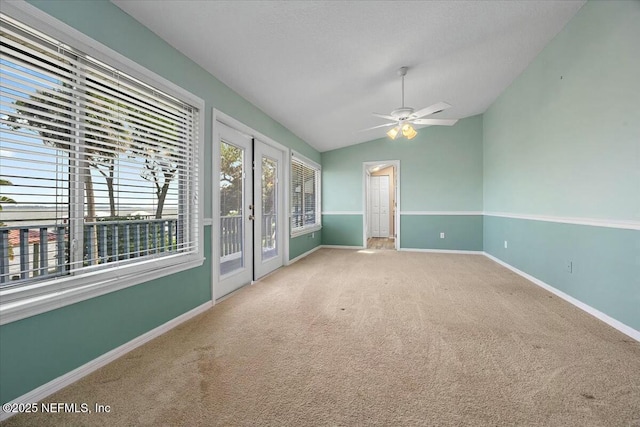 spare room featuring lofted ceiling, carpet, ceiling fan, and french doors