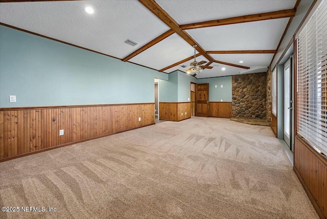 unfurnished room with ceiling fan, light colored carpet, lofted ceiling with beams, and a textured ceiling