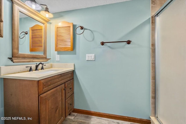 bathroom with vanity, a textured ceiling, and walk in shower