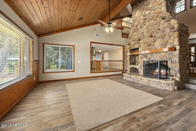 unfurnished living room with wood ceiling, high vaulted ceiling, wooden walls, hardwood / wood-style flooring, and a fireplace