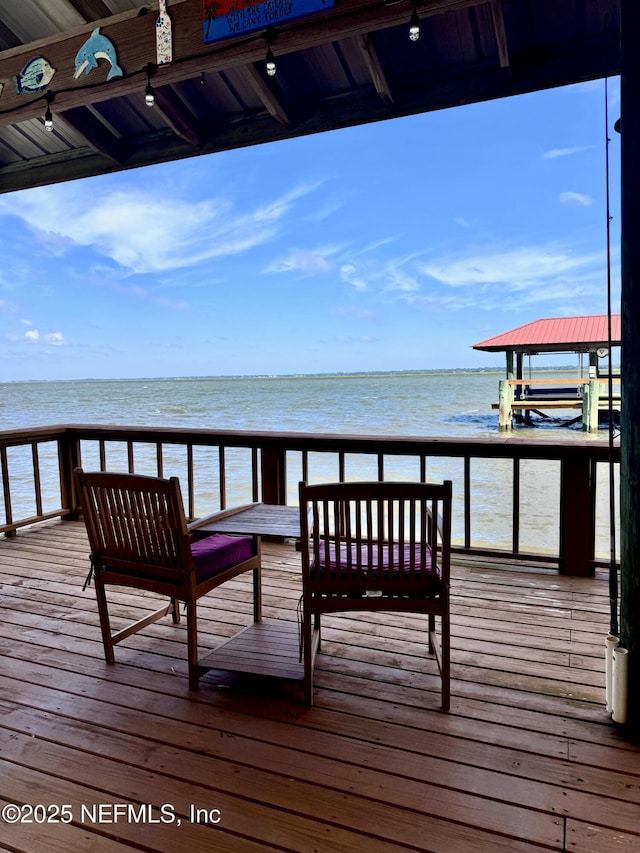 dock area featuring a deck with water view and a beach view