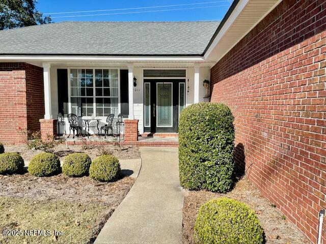 view of exterior entry with covered porch