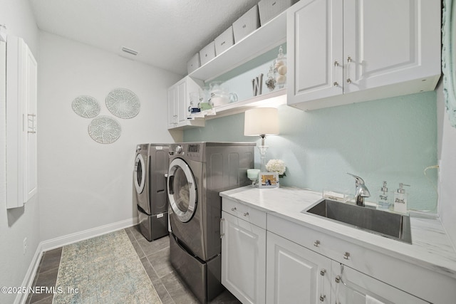 laundry area with cabinets, washer and clothes dryer, and sink