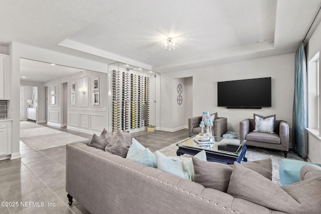 tiled living room with a raised ceiling and a textured ceiling