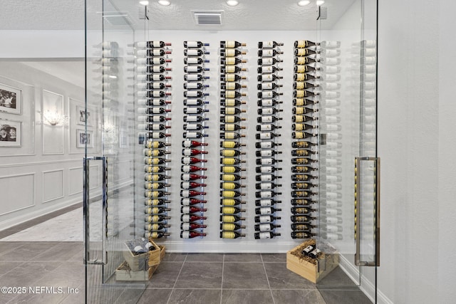 wine cellar with tile patterned flooring and a textured ceiling