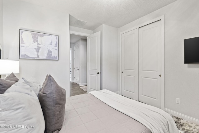 bedroom featuring a textured ceiling and a closet