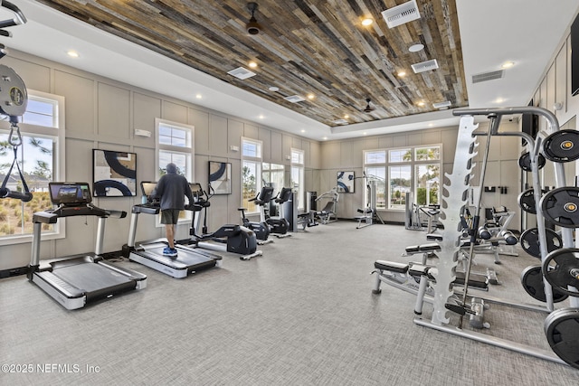 workout area featuring a towering ceiling and wooden ceiling