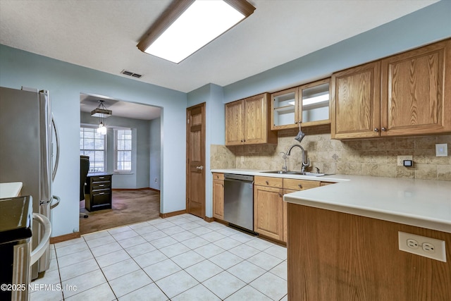 kitchen with backsplash, stove, light tile patterned flooring, dishwasher, and sink