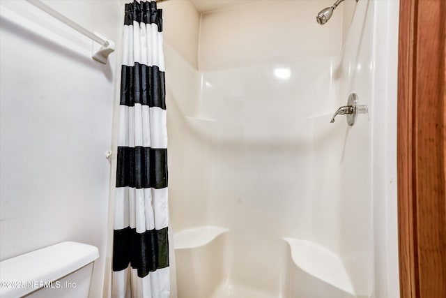 bathroom with toilet and curtained shower