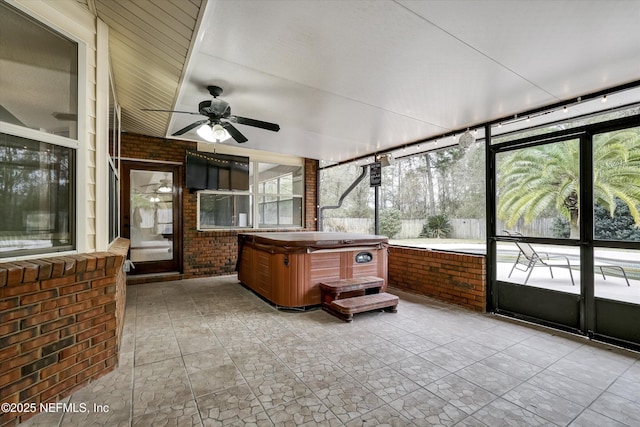 sunroom / solarium with ceiling fan and a hot tub