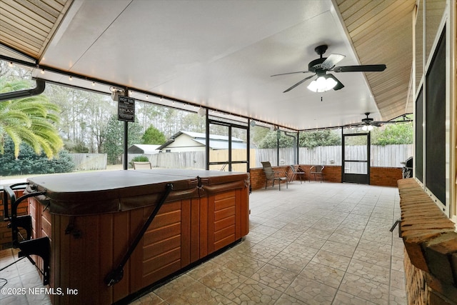 sunroom featuring ceiling fan, a wealth of natural light, and a hot tub