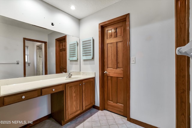 bathroom featuring a textured ceiling, tile patterned floors, and vanity