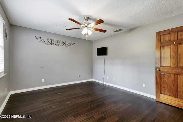 empty room featuring ceiling fan, a textured ceiling, and dark hardwood / wood-style floors