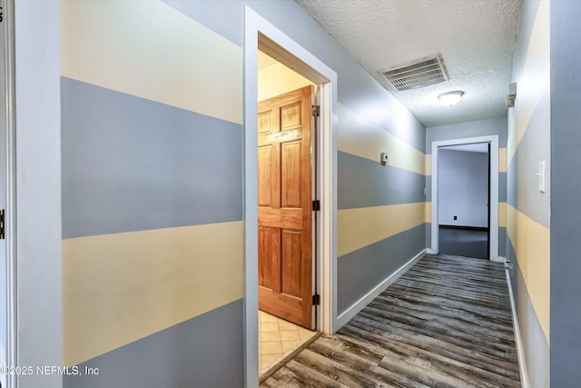 hall featuring a textured ceiling and light hardwood / wood-style flooring