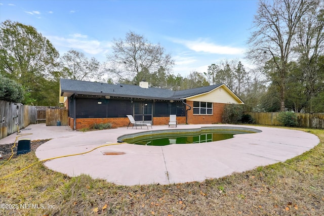 back of property featuring a fenced in pool, a patio, and a sunroom