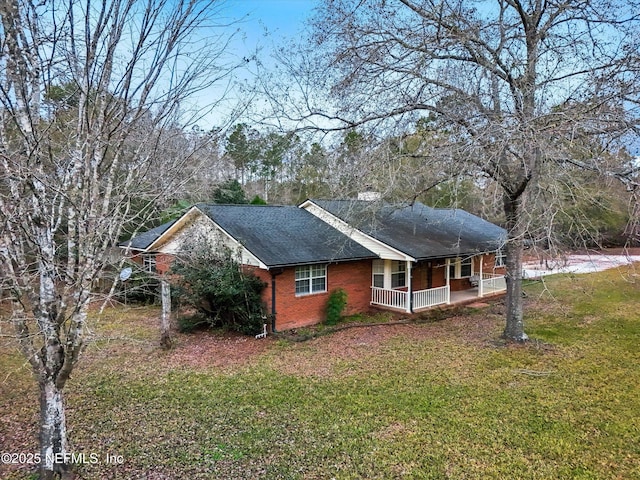 view of side of home featuring a porch and a yard