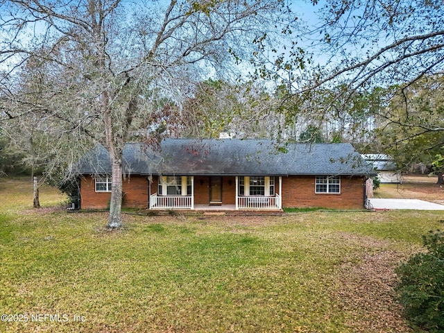 ranch-style house featuring covered porch and a front lawn