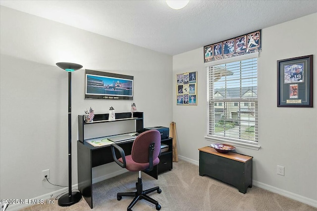 carpeted home office featuring a textured ceiling