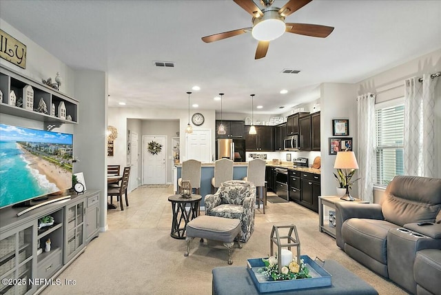 carpeted living room with ceiling fan