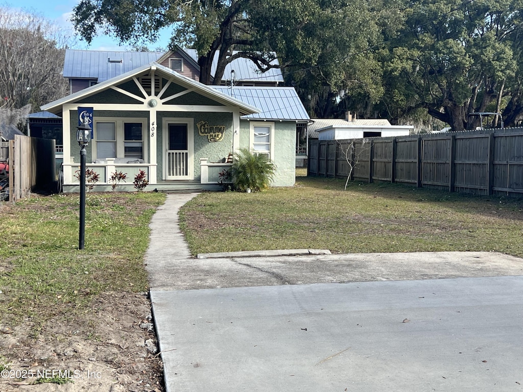 bungalow featuring covered porch and a front lawn