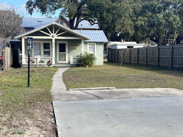 bungalow featuring covered porch and a front lawn