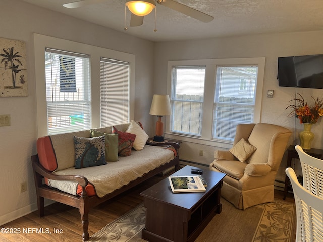 living room featuring ceiling fan, baseboard heating, and hardwood / wood-style floors