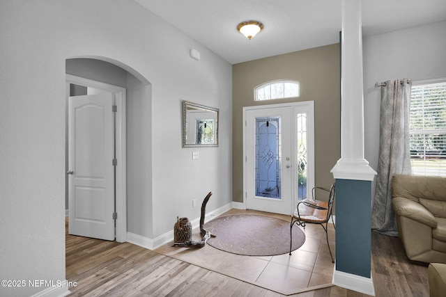 foyer featuring ornate columns and hardwood / wood-style floors