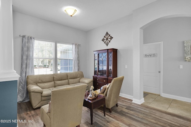 living room with decorative columns and wood-type flooring