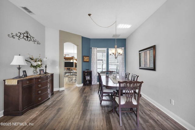 dining area with dark hardwood / wood-style flooring and an inviting chandelier