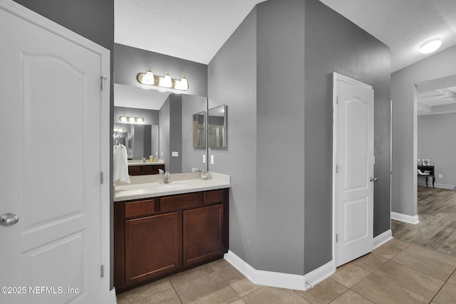 bathroom with a textured ceiling, tile patterned floors, and vanity