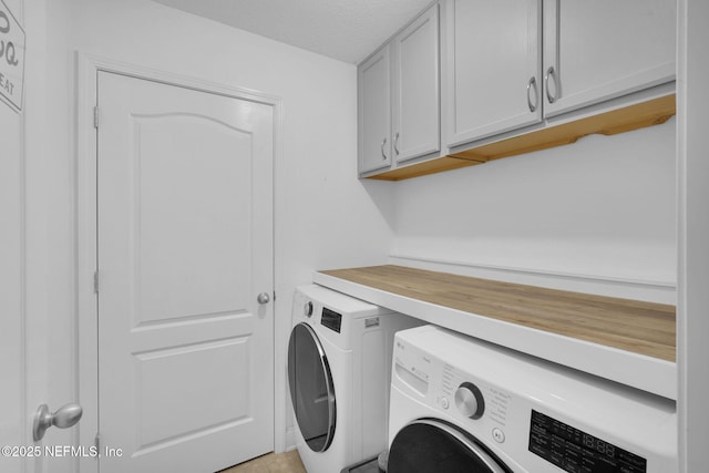 laundry room featuring separate washer and dryer, a textured ceiling, and cabinets