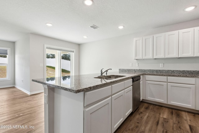 195 River Rdg Pl, Welaka, FL 32193 - kitchen with sink, white cabinetry, stainless steel dishwasher, kitchen peninsula, and stone counters