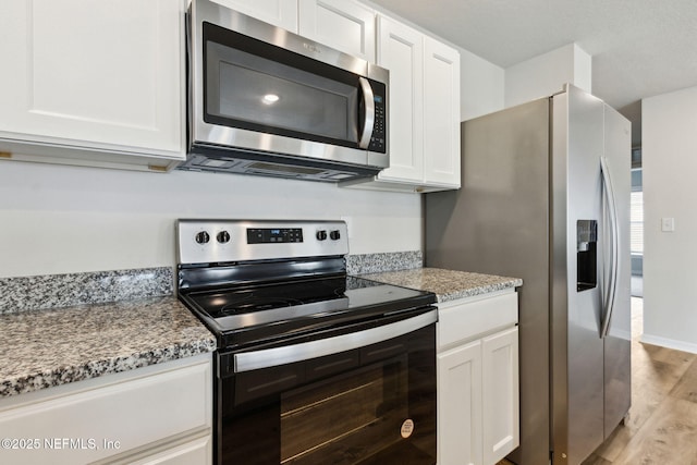 195 River Rdg Pl, Welaka, FL 32193 - kitchen featuring white cabinetry, light stone countertops, appliances with stainless steel finishes, and light hardwood / wood-style floors