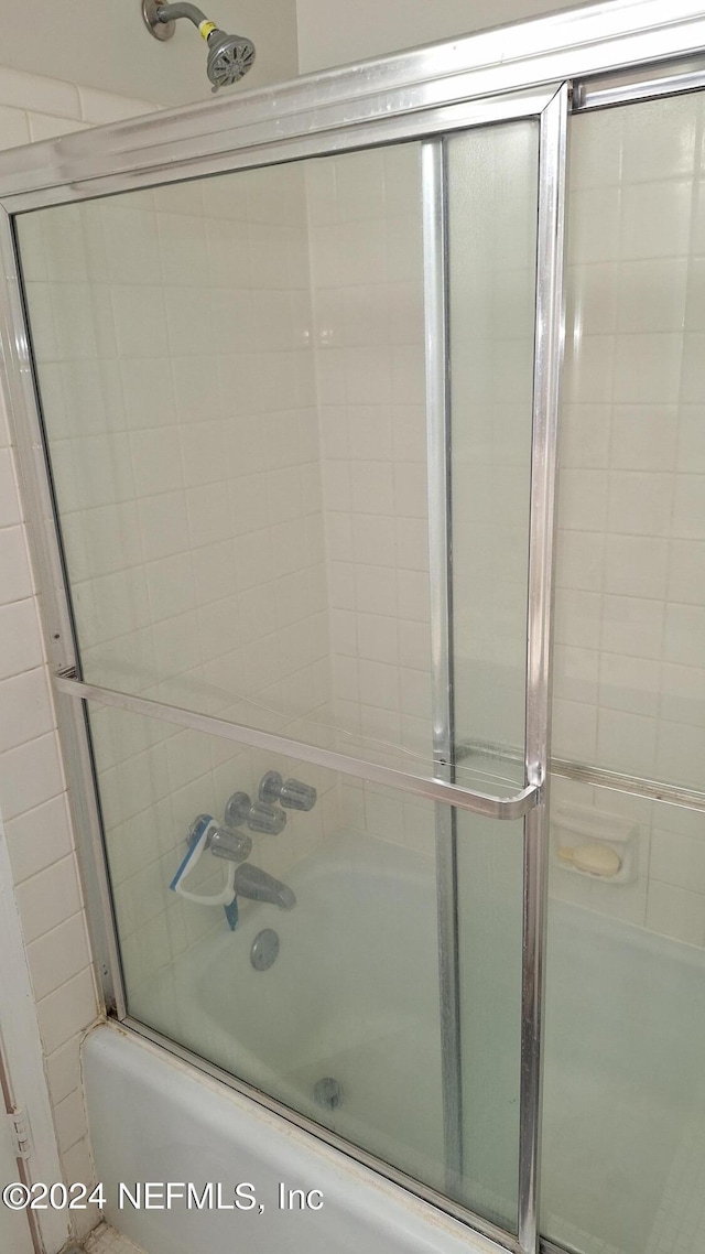 bathroom with shower / bath combination with glass door