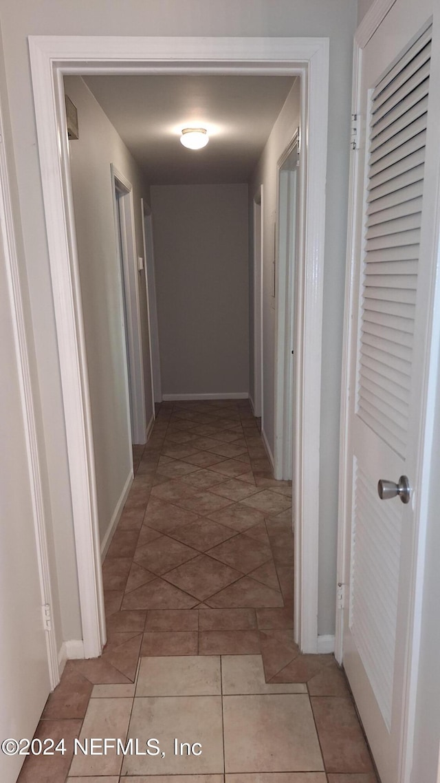 hall featuring light tile patterned flooring