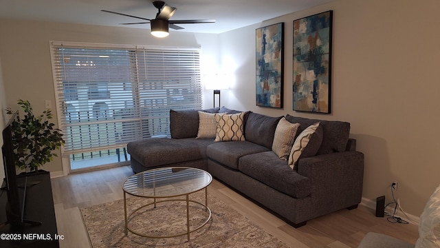 living room with ceiling fan, light wood-type flooring, and a wealth of natural light