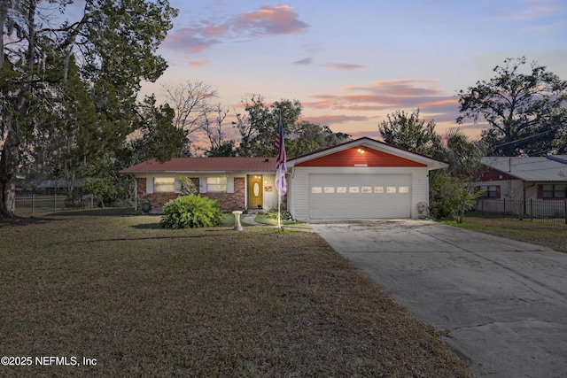 ranch-style house featuring a garage and a yard