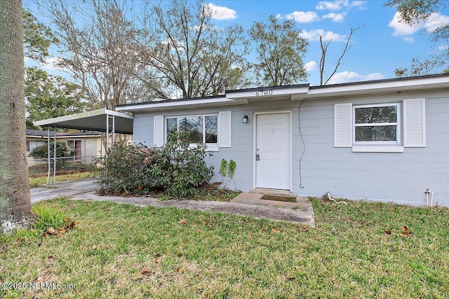 ranch-style house with a front yard and a carport