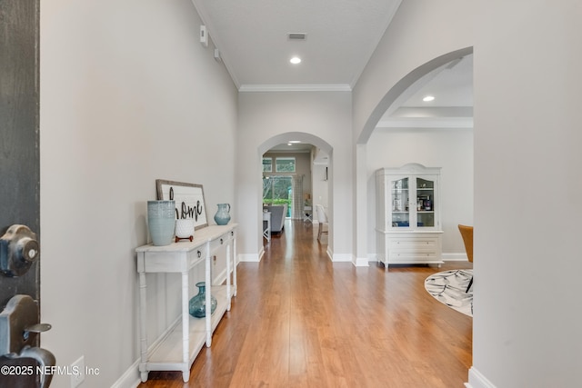 hallway featuring wood-type flooring and ornamental molding