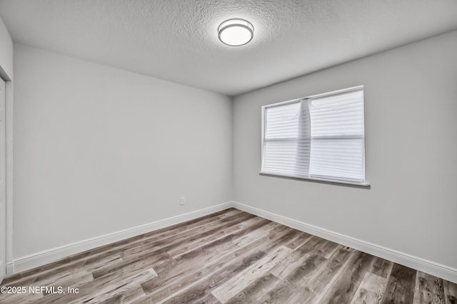 unfurnished room featuring hardwood / wood-style floors and a textured ceiling