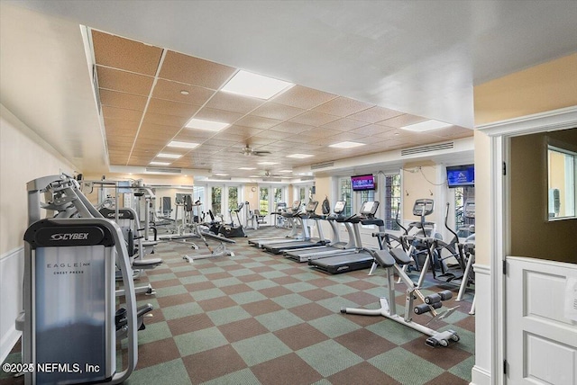 gym with ceiling fan and a drop ceiling